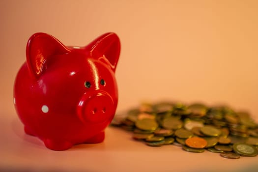 A red piggy bank full of coins. High quality photo