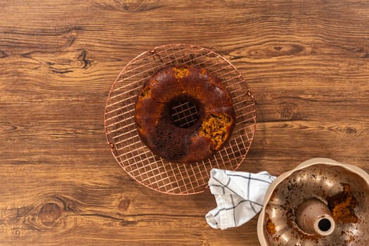Flat lay. The gingerbread bundt cake cools gracefully on a wire rack, awaiting its sweet caramel frosting.