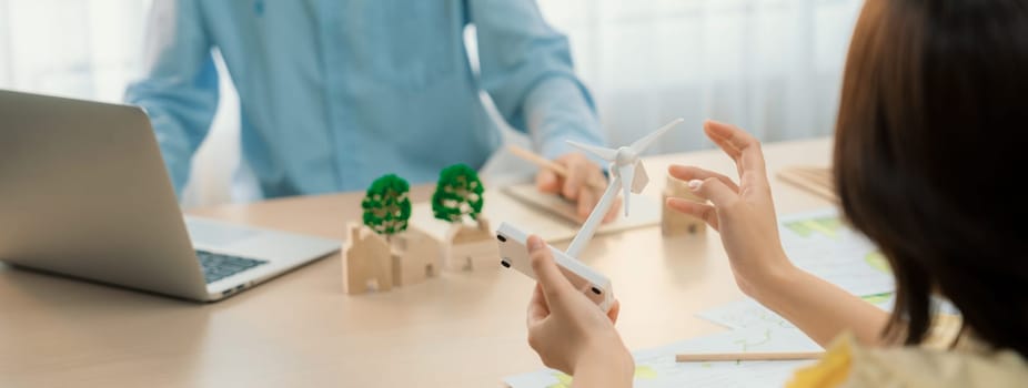 Businesswoman interested in investing in renewable energy at meeting table with environmental document scatter around. Business team discussion about green business project. Closeup. Delineation.