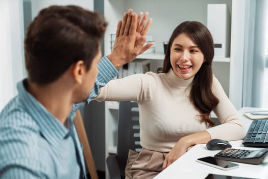 Smiling happy coworkers making hand high five also raising fist up of successful creative business project plan with highest profit value job in casual day at modern office at morning time. Postulate.