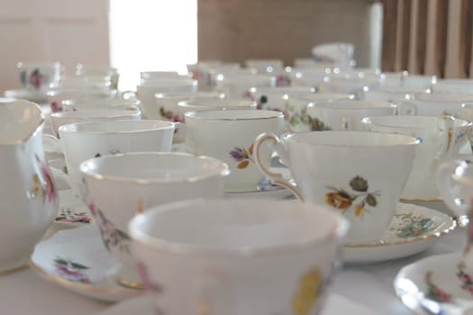 A collection of vintage floral teacups and saucers arranged on a table.