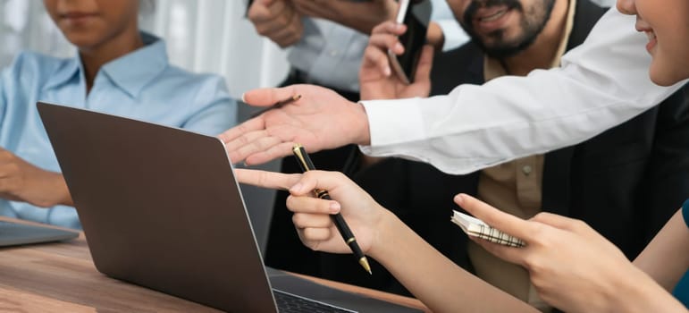 Diverse business people work together, discuss in corporate office. Professional teamwork discussing and pointing at laptop. Modern multicultural office worker. Concord