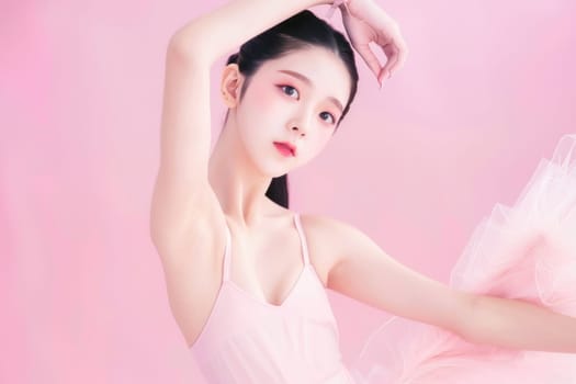 Elegant asian ballerina in pink tutu skirt dancing gracefully on pink background for beauty and art concepts