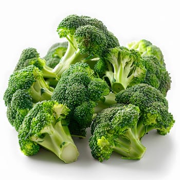 Broccoli, a leaf vegetable and superfood, is a staple food and common ingredient in various cuisines. This pile of broccoli is on a white surface, ready to be used in a dish