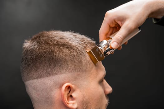 Hairdresser shapes mans hair on the forehead.