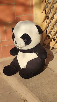 large soft children's toy panda bear thrown out on the street. High quality photo
