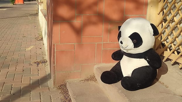 large soft children's toy panda bear thrown out on the street. High quality photo