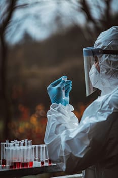 A veterinarian in a protective suit takes tests on animals on a farm. Selective focus. animal.