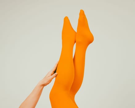 Female legs in ocher tights on a white background