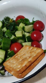 food vegetables cherry tomatoes, cucumbers greens and crackers. High quality photo