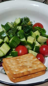 food vegetables cherry tomatoes, cucumbers greens and crackers. High quality photo