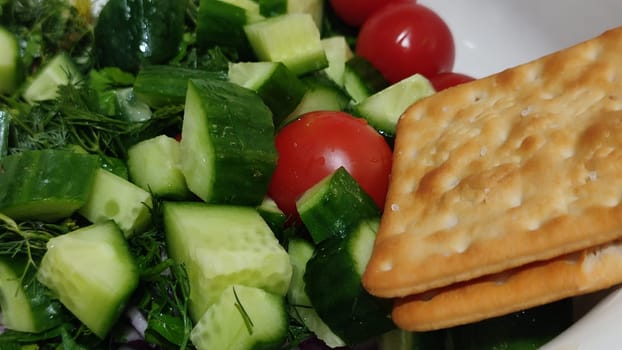 food vegetables cherry tomatoes, cucumbers greens and crackers. High quality photo