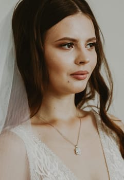 Portrait of one young very beautiful brunette bride looking lovingly away,side view close-up.