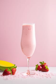 Strawberry milkshake in a glass on a pink background. The concept of summer soft drinks. Generative AI
