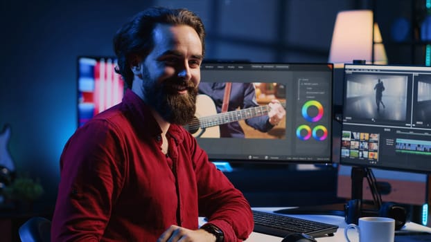 Happy videographer reviewing footage and selecting scenes, trimming them using specialized software applications and editing tools. Smiling video editor working for media company in editing room