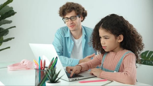 American daughter learning to coding and writing engineering prompt while positive smart father studying together and pointing at laptop screen to show programing code or system with care. Pedagogy.