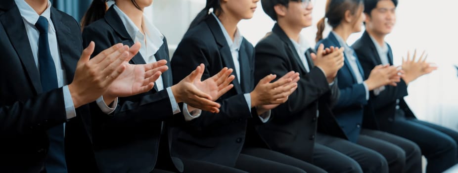 Business people gather in line at corporate event to applaud achievement and celebrate company's success on motivation speech or business presentation meeting with audience in panorama banner. Shrewd