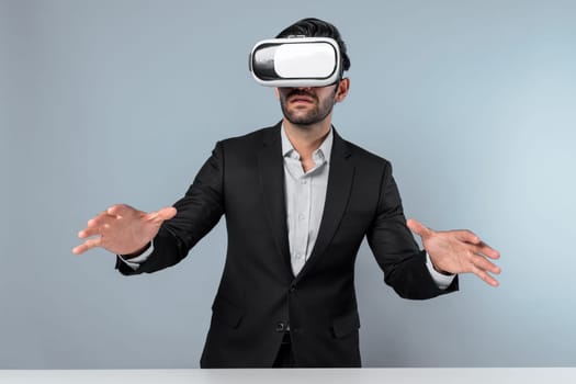 Skilled businessman looking at financial chart while wearing VR goggle. Professional project manager checking data analysis while connecting metaverse or virtual reality world. Innovation. Deviation.