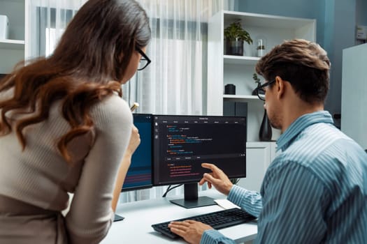 Team skilled developers program coding discussing creative website planning software project on two screen monitor's full stack data analyzing design at office with back side view concept. Postulate.