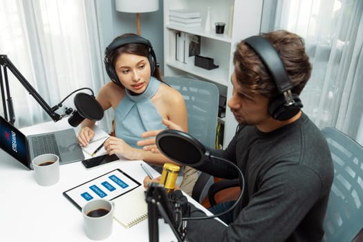 Top view of host channel broadcasters discussing together, making advice for problem in live streaming with listeners surrounded sets of live streaming radio talking show at modern studio. Postulate.