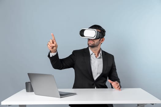 Professional project manager looking by using VR goggle while sitting at laptop. Skilled business man wearing visual reality headset while connecting metaverse or visual world. Innovation. Deviation.