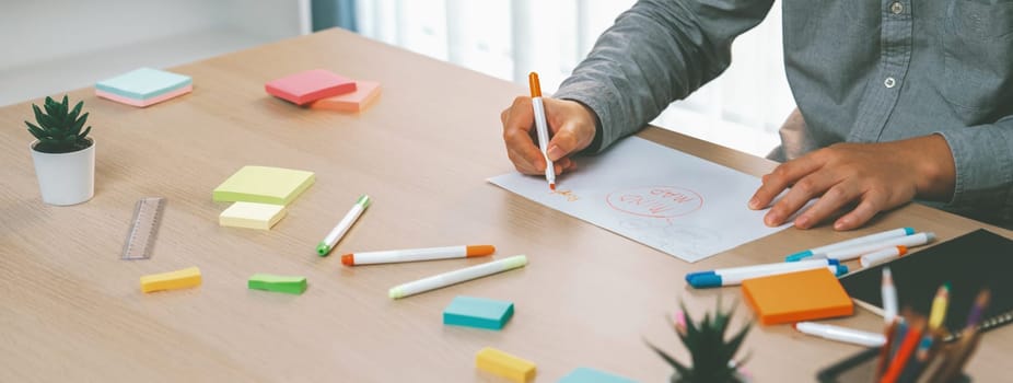 Skilled businessman brainstorms marketing ideas using mind maps. Successful male startup leader drafts financial plan on table with sticky notes scatter around. Closeup. Focus on hand.Variegated.