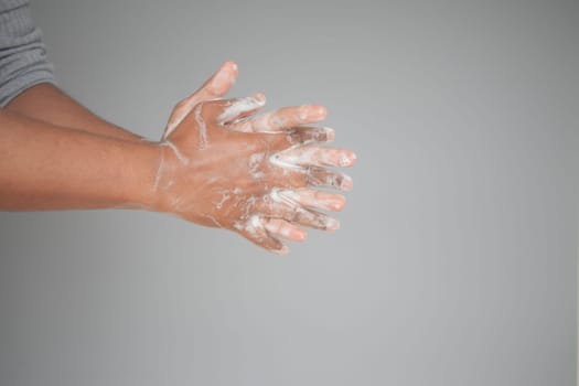 young man washing hands with soap warm water.