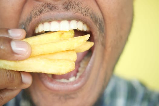 hungry man eating fries closeup,