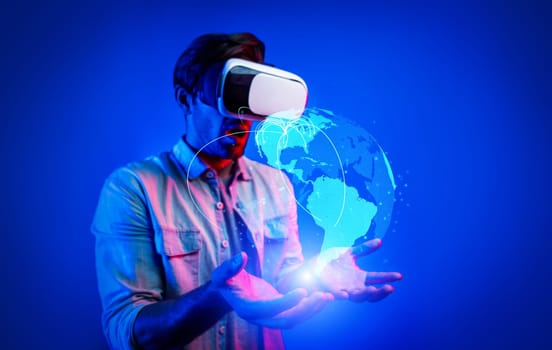 Smart man using VR goggle to connect global network connection. Happy man with casual cloth access futuristic global cloud computing server or software by wearing visual reality headset. Deviation.