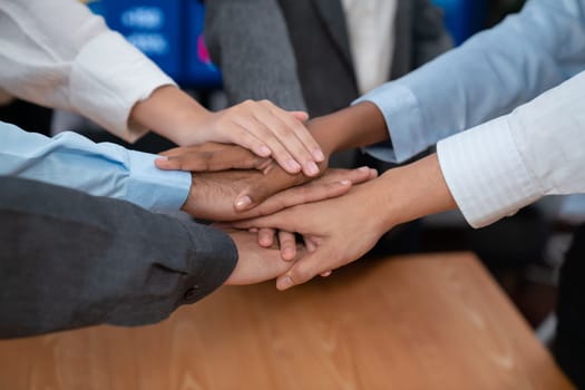 Multiracial office worker's hand stack shows solidarity, teamwork and trust in diverse community. Businesspeople unite for business success through synergy and collaboration by hand stacking. Concord