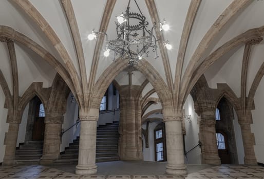 Munich, Germany - Dec 21, 2023 - Gothic architectural style with arches of Famous New Town Hall (Neues Rathaus) on Marienplatz square in Munich. Beautiful Hall with Ceiling, Pillars, Lamp and Cathedral, Space for text, Selective focus.