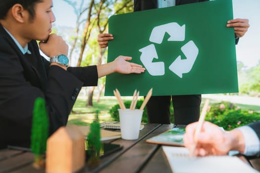 Group of businesspeople meeting at outdoor office in the nature planning and brainstorming on recycle strategy for greener environment by reducing and reusing recyclable waste. Gyre