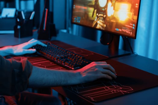 Host channel of young gaming streamer, team gamer playing battle game with multiplayer at warship on pc screen with cropped back side image, wearing headset with mic at digital neon room. Gusher.