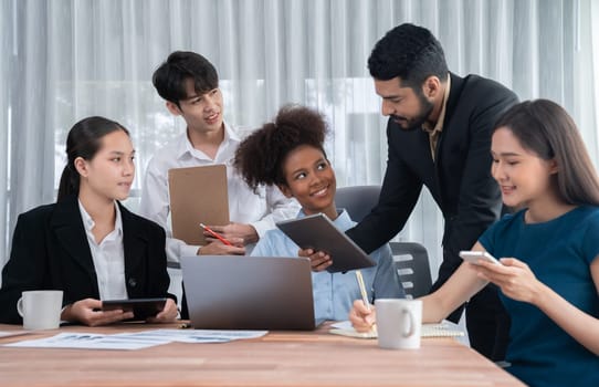 Happy diverse business people work together, discussing in corporate office. Professional and diversity teamwork discuss business plan on desk with laptop. Modern multicultural office worker. Concord