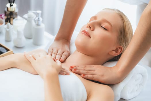 Caucasian woman customer enjoying relaxing anti-stress spa massage and pampering with beauty skin recreation leisure in day light ambient salon spa at luxury resort or hotel. Quiescent