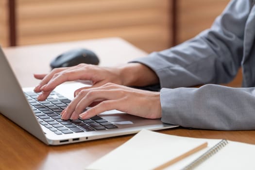 Businesswoman typing on laptop, working on business on workspace table. Young college student study or brainstorming strategic plan in office workplace for business success. Blithe