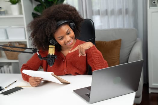 Host channel of beautiful African woman talking in online broadcast teaching marketing influencer, with listeners in broadcast or online. Concept of anywhere at work place. Tastemaker.