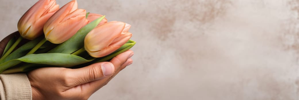Man holding beautiful tulip bouquet in kraft paper against light wall with copy space