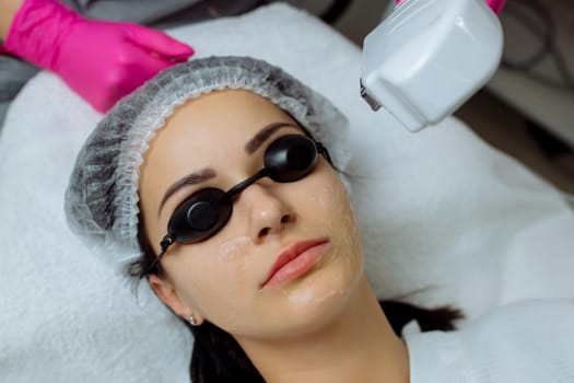 woman receiving procedure, skin rejuvenation at beauty salon. Elos procedure removes brown spots and narrows pores , smoothens fine wrinkles, slows down the age-related changes in skin