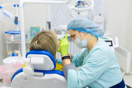 dentist drills the lower tooth to the patient sitting in a chair. High quality photo
