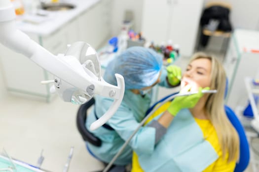 dentist drills the lower tooth to the patient sitting in a chair. High quality photo