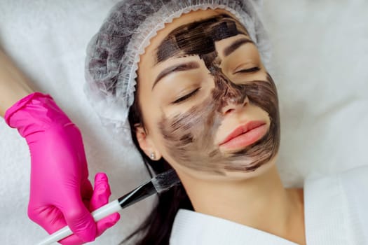 Close-up of carbon peeling procedure for middle-aged woman face. Laser pulses clean skin. Process of photothermolysis, warming, laser carbon peeling. Facial skin rejuvenation, cosmetology treatment