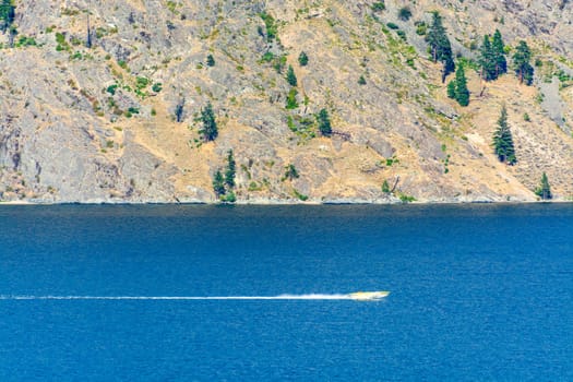 Power motor boat running over Okanagan lake with passengers on the board