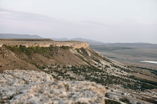 Breathtaking panoramic view of mountains from cliff top with valley below on a sunny day