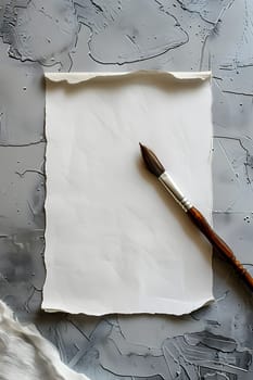 A grey twig with a small brush is placed on a rectangular wood table, next to a paper product featuring a intricate pattern. Still life photography with metal accents