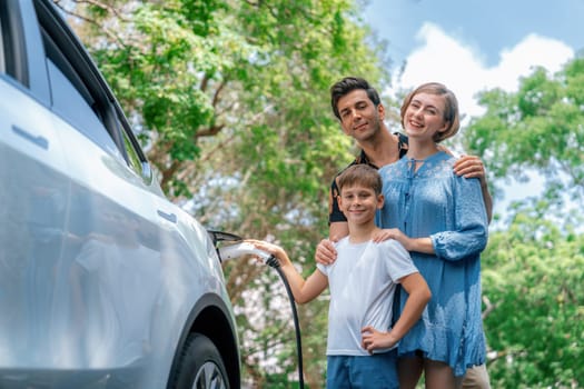 Family road trip vacation with electric vehicle, lovely family recharge EV car with green and clean energy. Natural and eco friendly car travel for sustainable environment. Perpetual