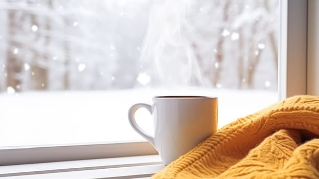 Winter holidays, calm and cosy home, cup of tea or coffee mug and knitted blanket near window in the English countryside cottage, holiday atmosphere inspiration