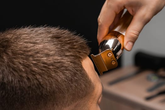 Close up hairdresser shapes mans hair on the forehead.