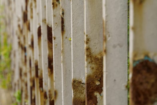 A detailed view of a weathered metal fence covered in rust.