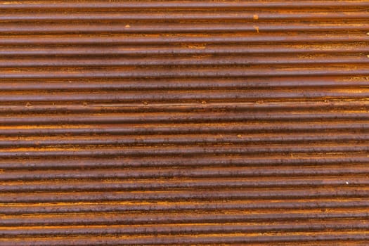 Detailed view of a textured brown corrugated metal wall.